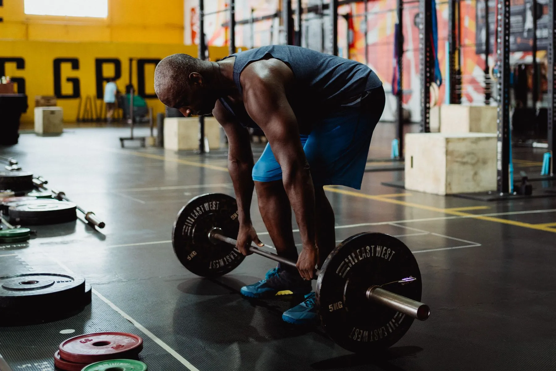 A lifter sets up a heavy barbell deadlift on a gym floor.